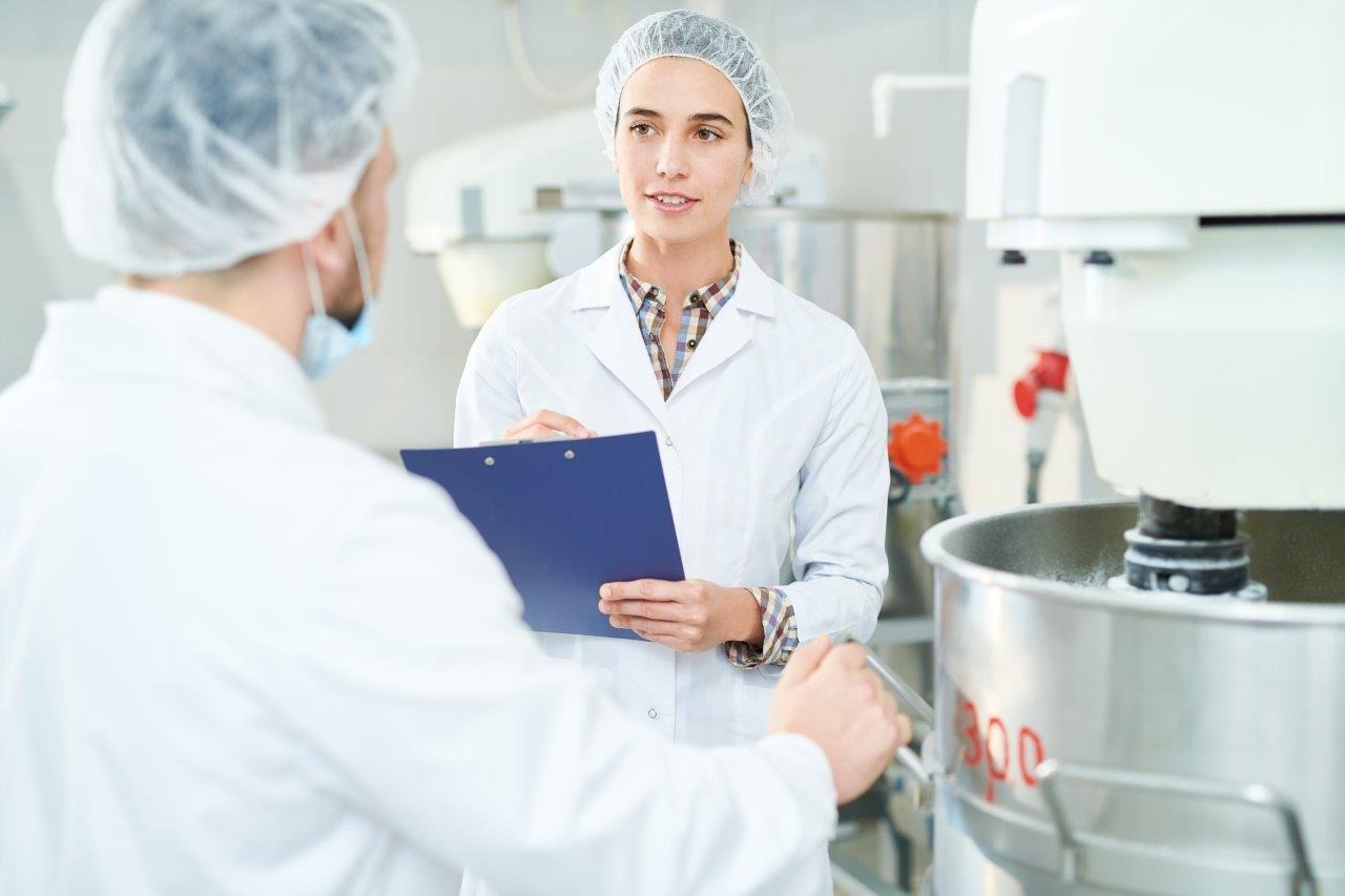 certyfikat ISO 22000 na ścianie obok półek z produktami spożywczymi w magazynie