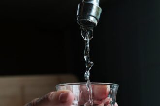 szklanka czystej wody pitnej nalewana z kuchennego kranu