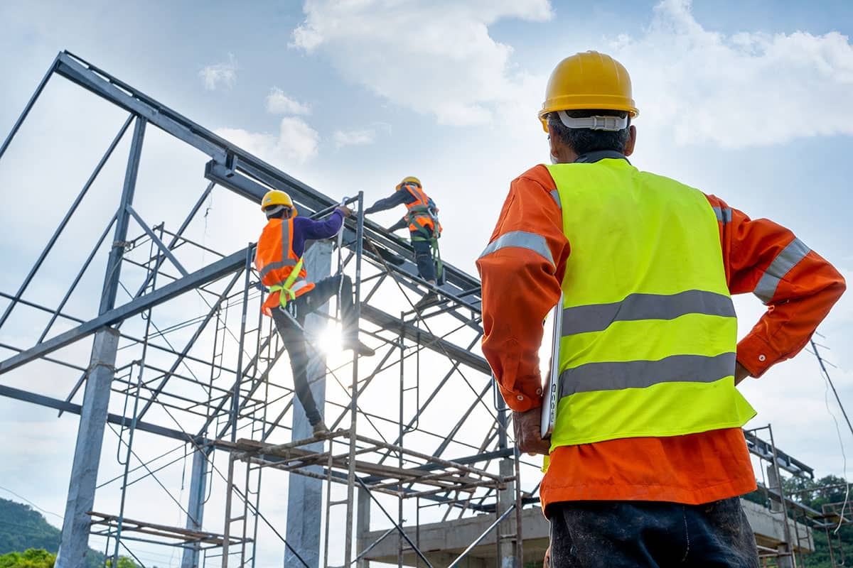 pracownik w okularach ochronnych i hełmie obsługujący instalację wysokiego napięcia