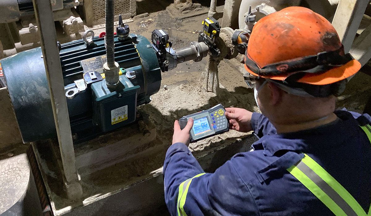 Technik mierzy hałas sonometrem przy pracującej prasie hydraulicznej