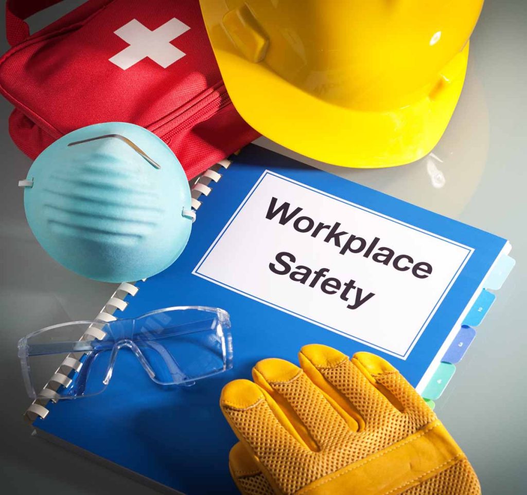 robotnicy w kaskach i kamizelkach na uporządkowanym placu budowy z barierkami