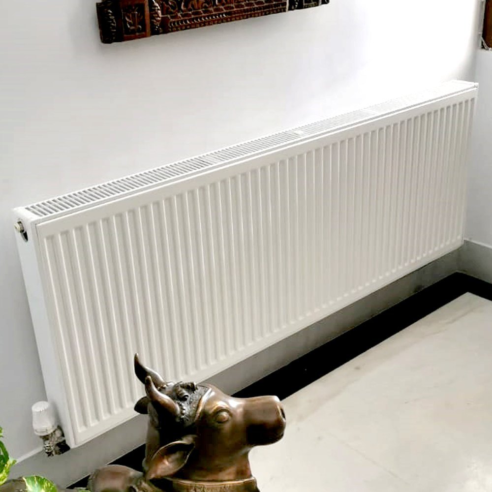 modernizacja starego ogrzewania stare żeliwne grzejniki obok nowoczesnych konwektorowych