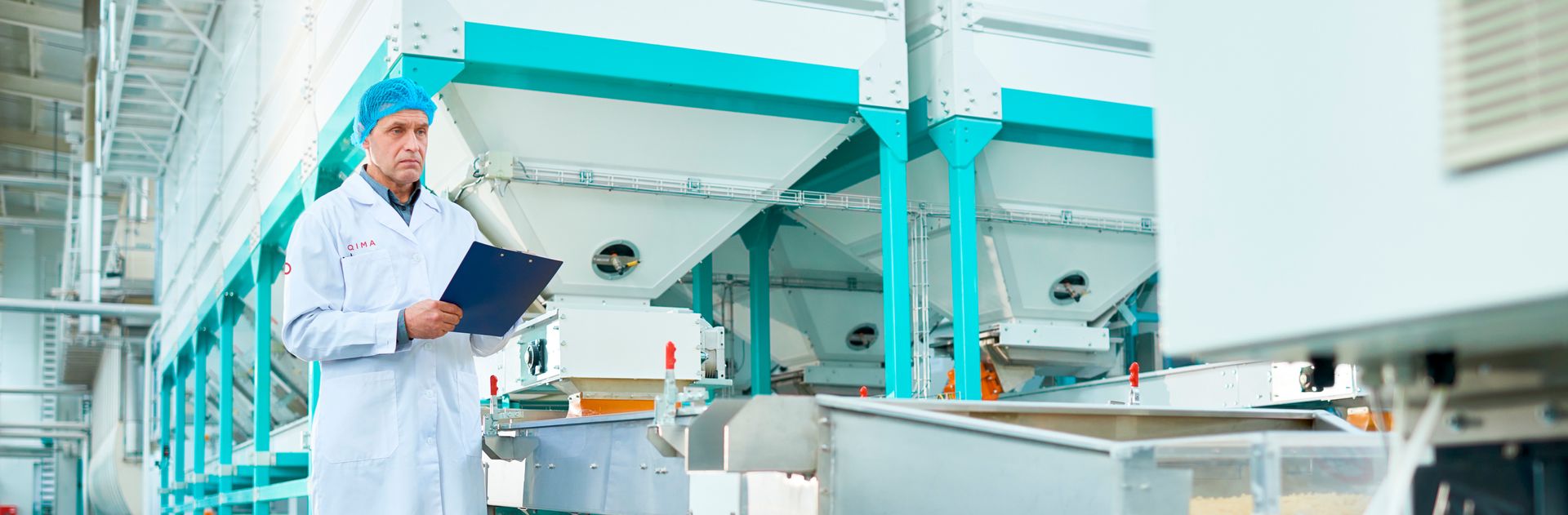 inżynier zaznaczający punkty krytyczne na planie hali produkcyjnej żywności