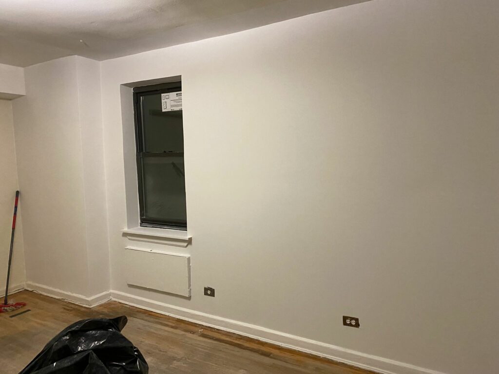 inspektor notuje w protokole wady tynku trzymając miarkę