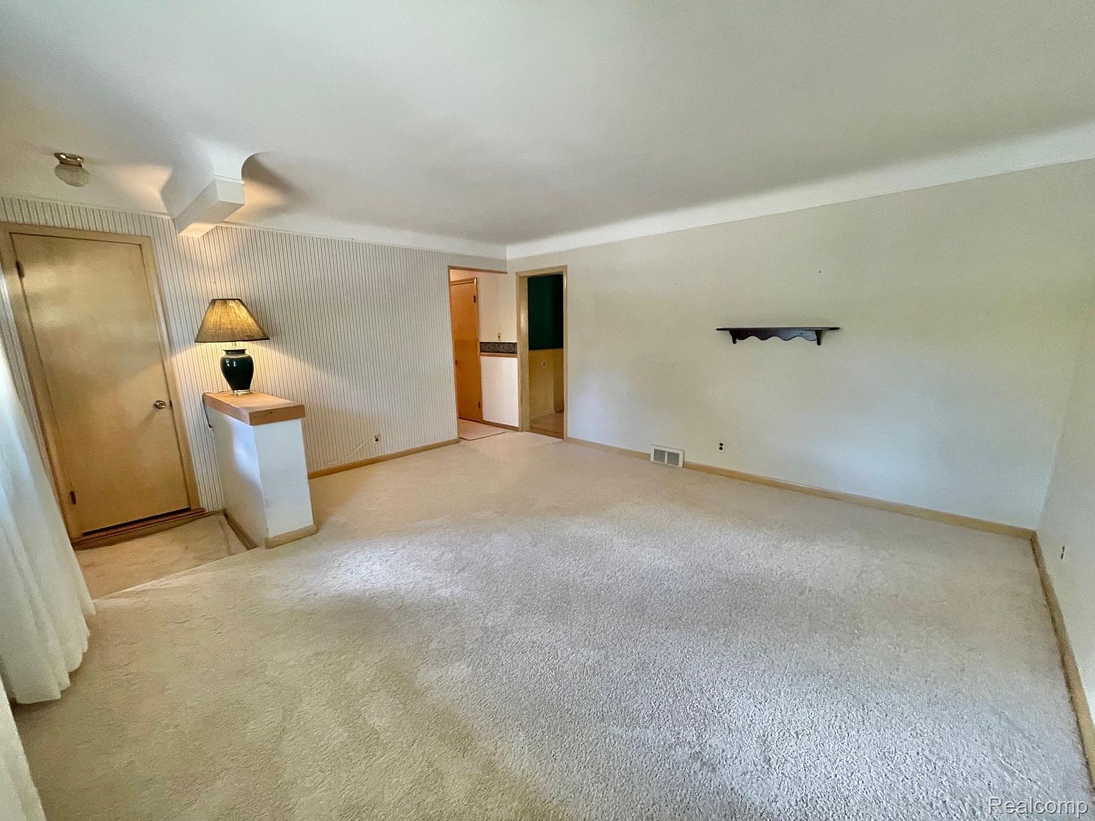 inspektor w kasku sprawdza poziomicą ściany w pustym mieszkaniu deweloperskim