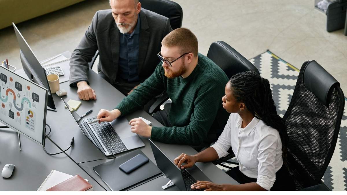 programista i klient podający sobie ręce przy stole z podpisaną umową projektową