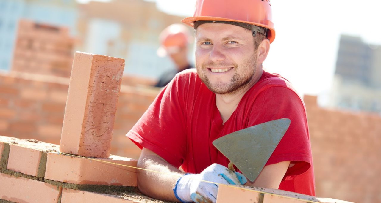 robotnik tnący cegłę piłą diamentową na stole warsztatowym