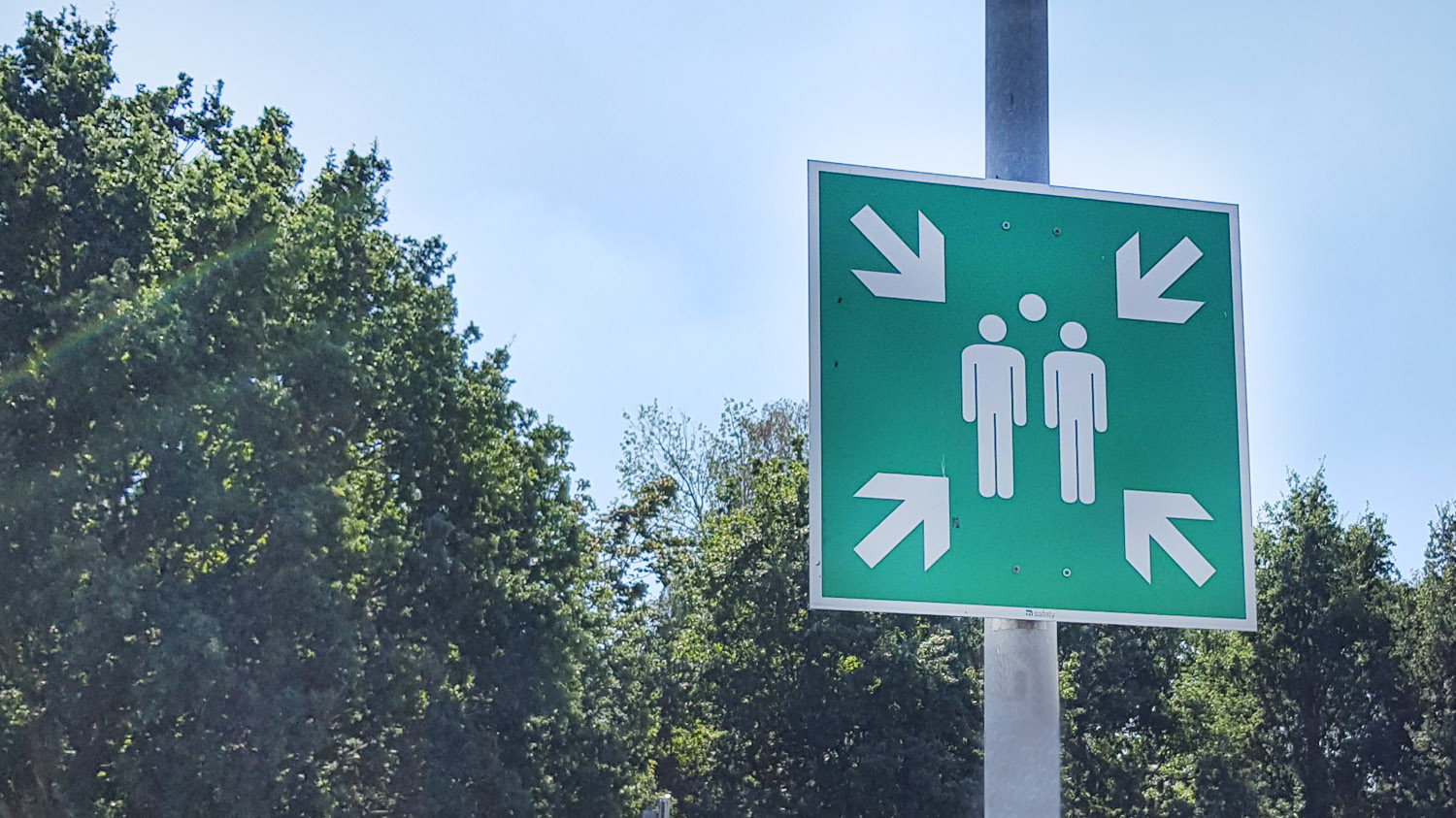 Zielone znaki ewakuacyjne na suficie klatki schodowej w biurowcu